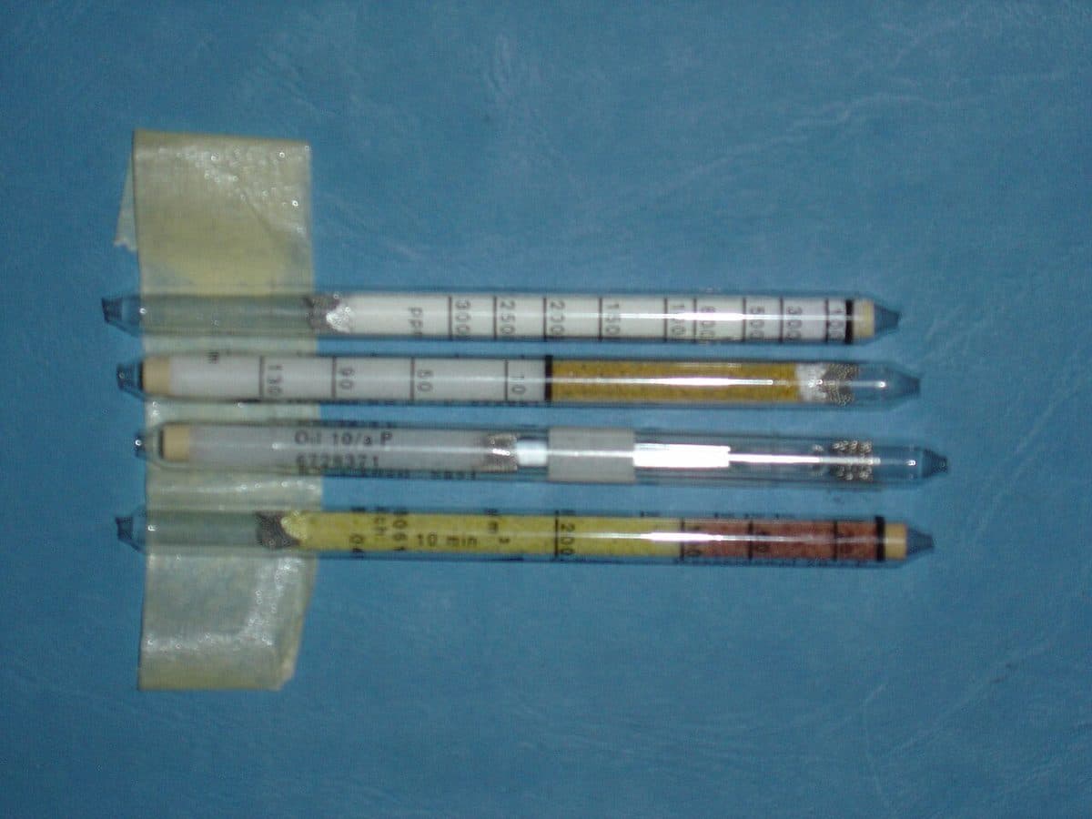 Cuatro tubos colorimétricos Dräger usados, entre ellos el Oil 10/a-P, tras una prueba de aire respirable